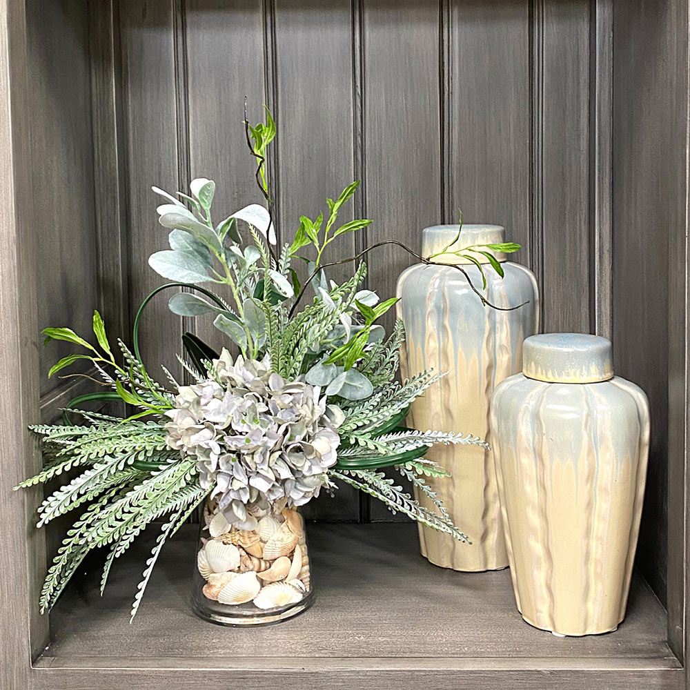 Creative Displays Floral Arrangement with Seafoam Hydrangea, Lambs Ear, Fern, Shells, Vine and Grass Blade in Clear Glass Vase
