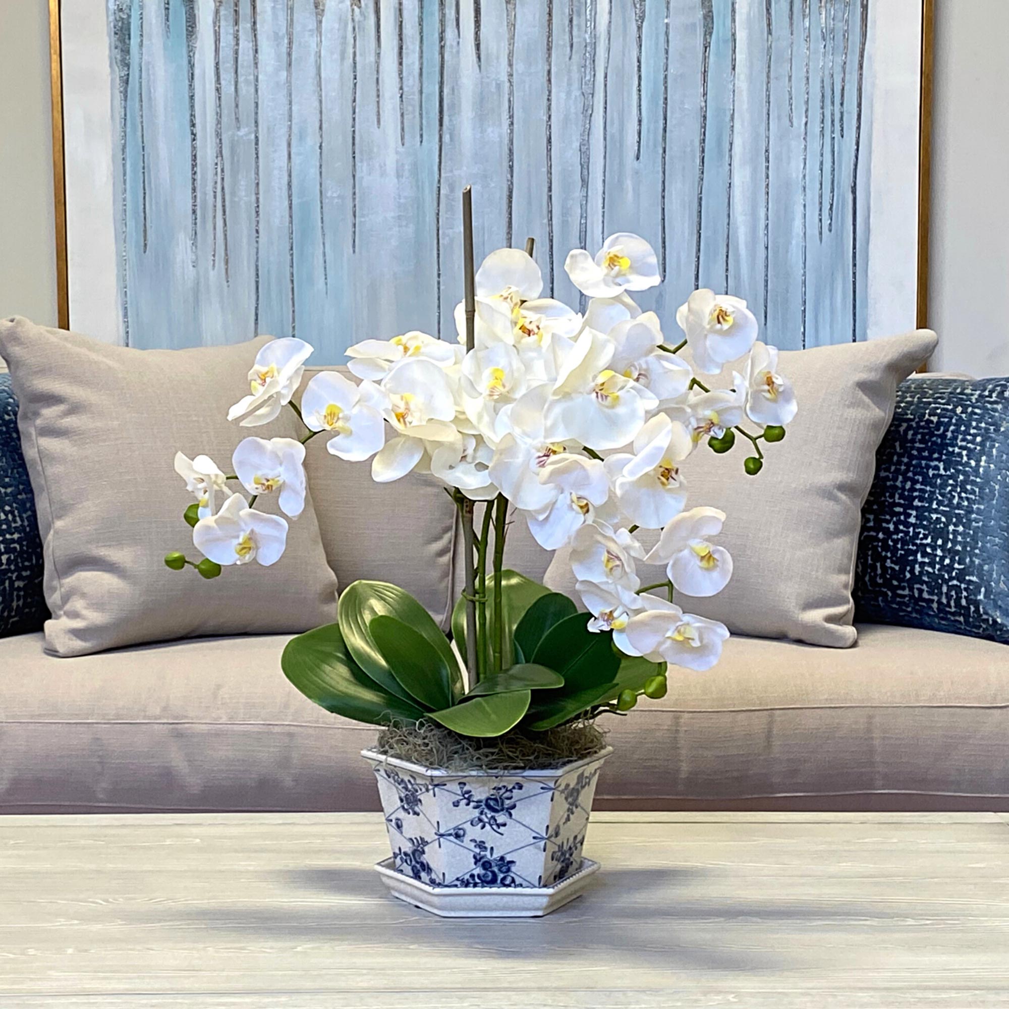 Creative Displays Floral Arrangement with White Orchids, Leaves and Bamboo in Blue/White Decorative Ceramic Vase