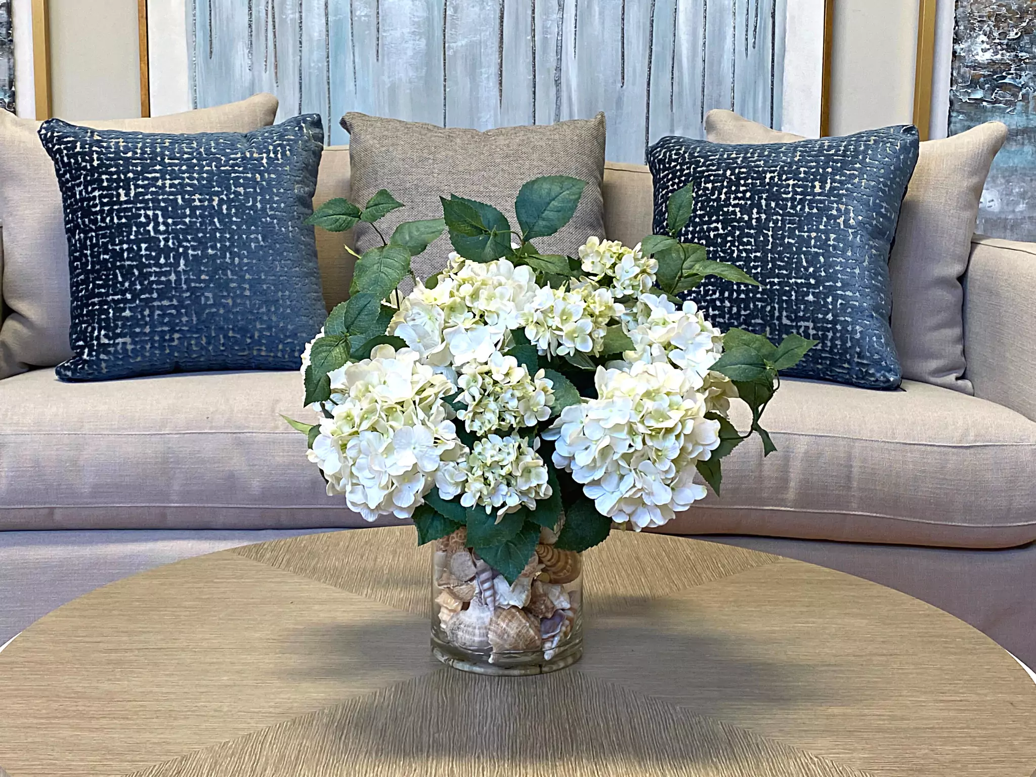 Hydrangea Floral Arrangement in a Clear Glass Vase with Seashells